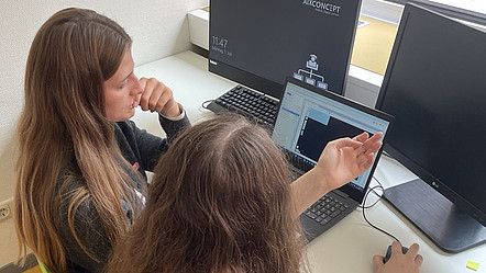 Zwei Schülerinnen sitzen an einem Laptop